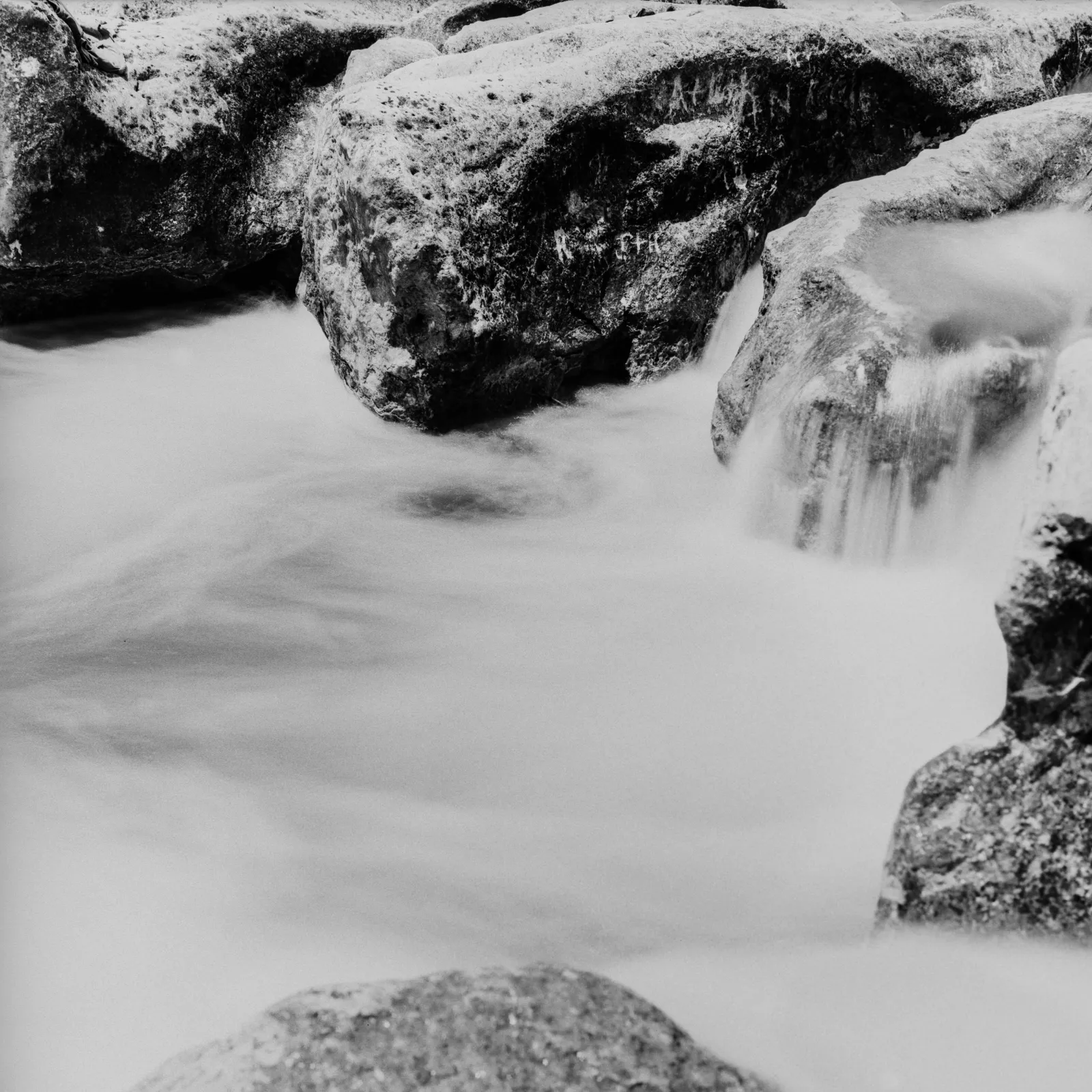 Rushing water and etched rock at Sculpture falls in the greenbelt